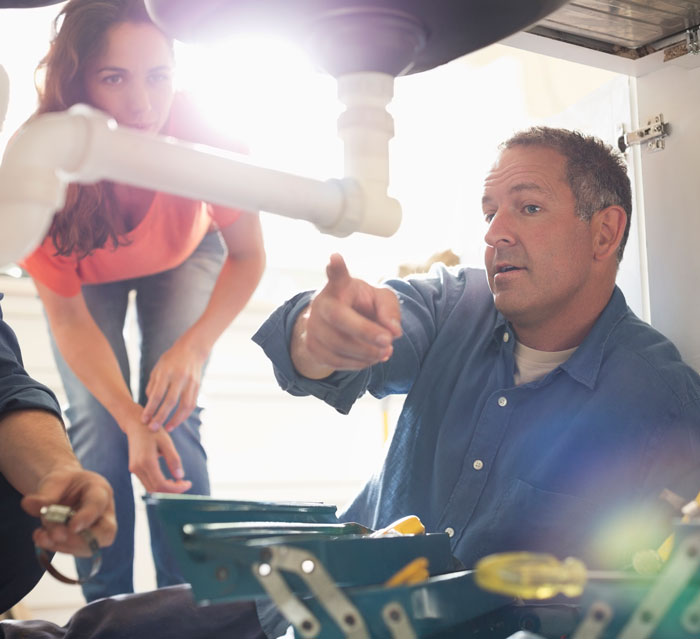 Plumber explaining repairs to a new customer