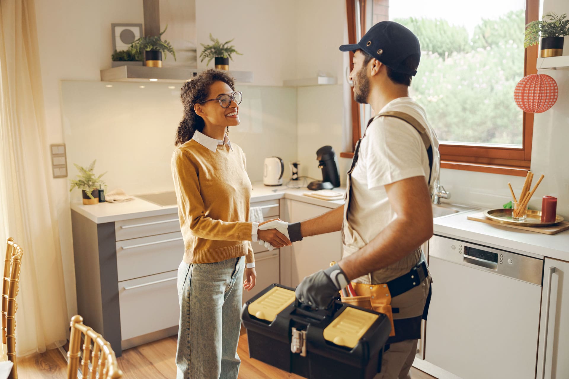 A plumber shaking the hand of a women who requesting his help with a plumbing repair