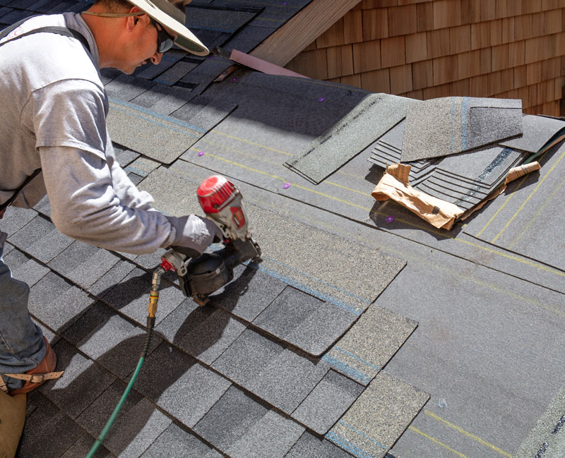 Roofer Working on a new room laying shingles