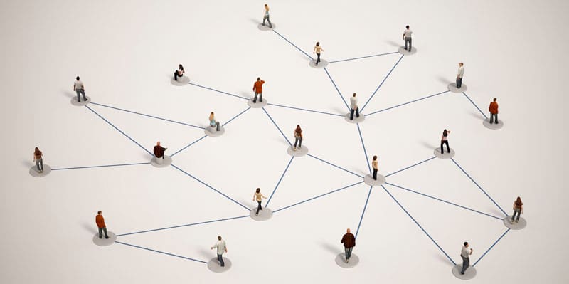 Miniature People Connected by Lines on a White Surface.