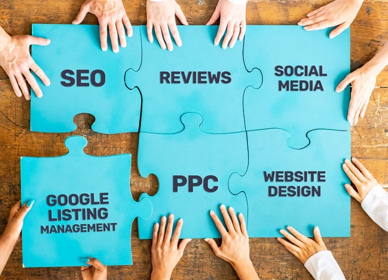 hands putting puzzle pieces together that have digital marketing services on them