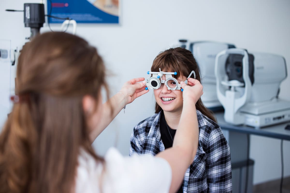 Optometrist-01 Teenage girl sitting at doctor's office and having her eyesight checked